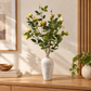 Yellow rose stems in speckled white vase, green leaves and yellow buds