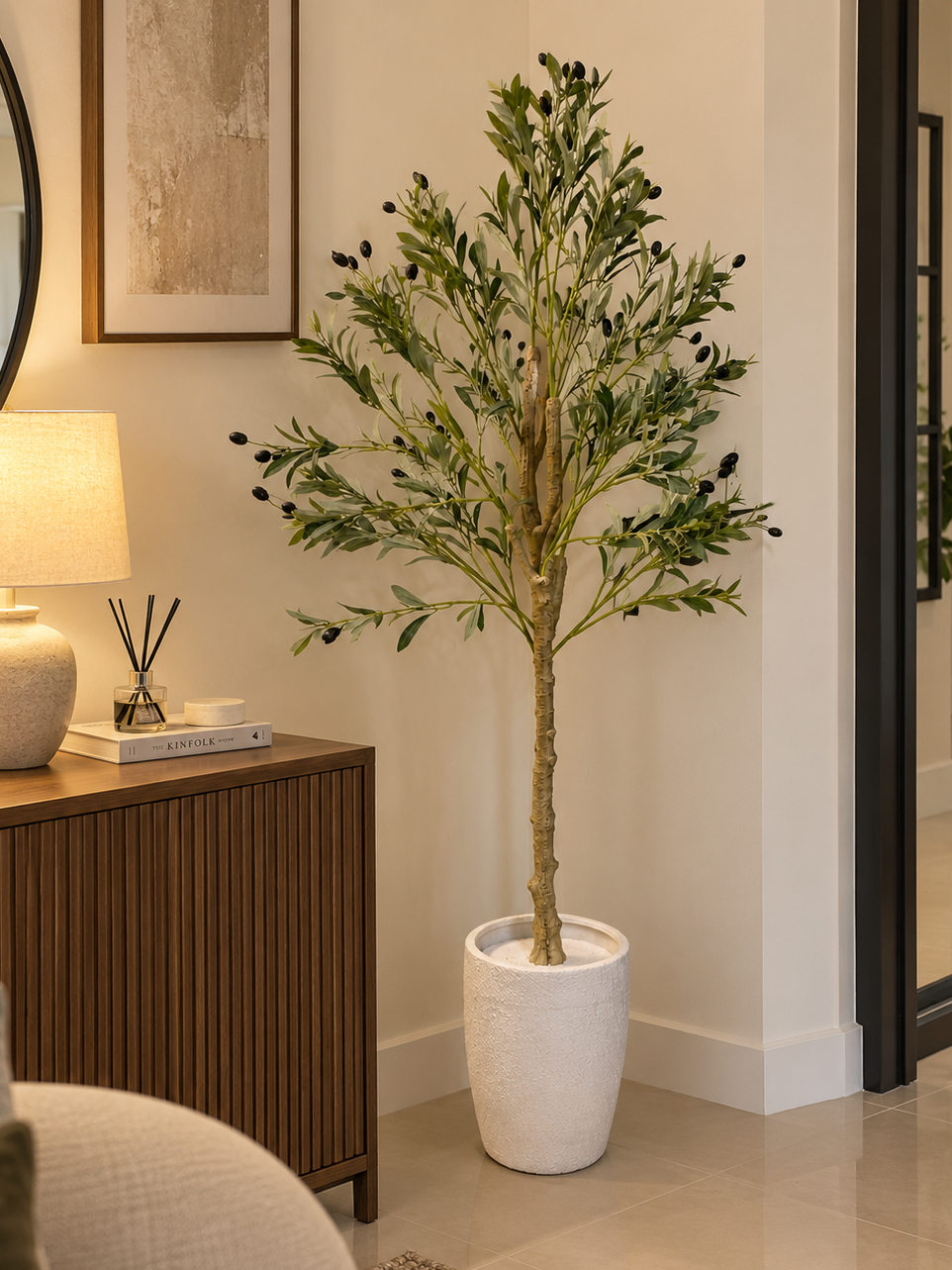 Potted olive tree with dense green leaves in a white fabric pot