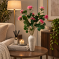 Pink roses and buds with green leaves in tall speckled white vase