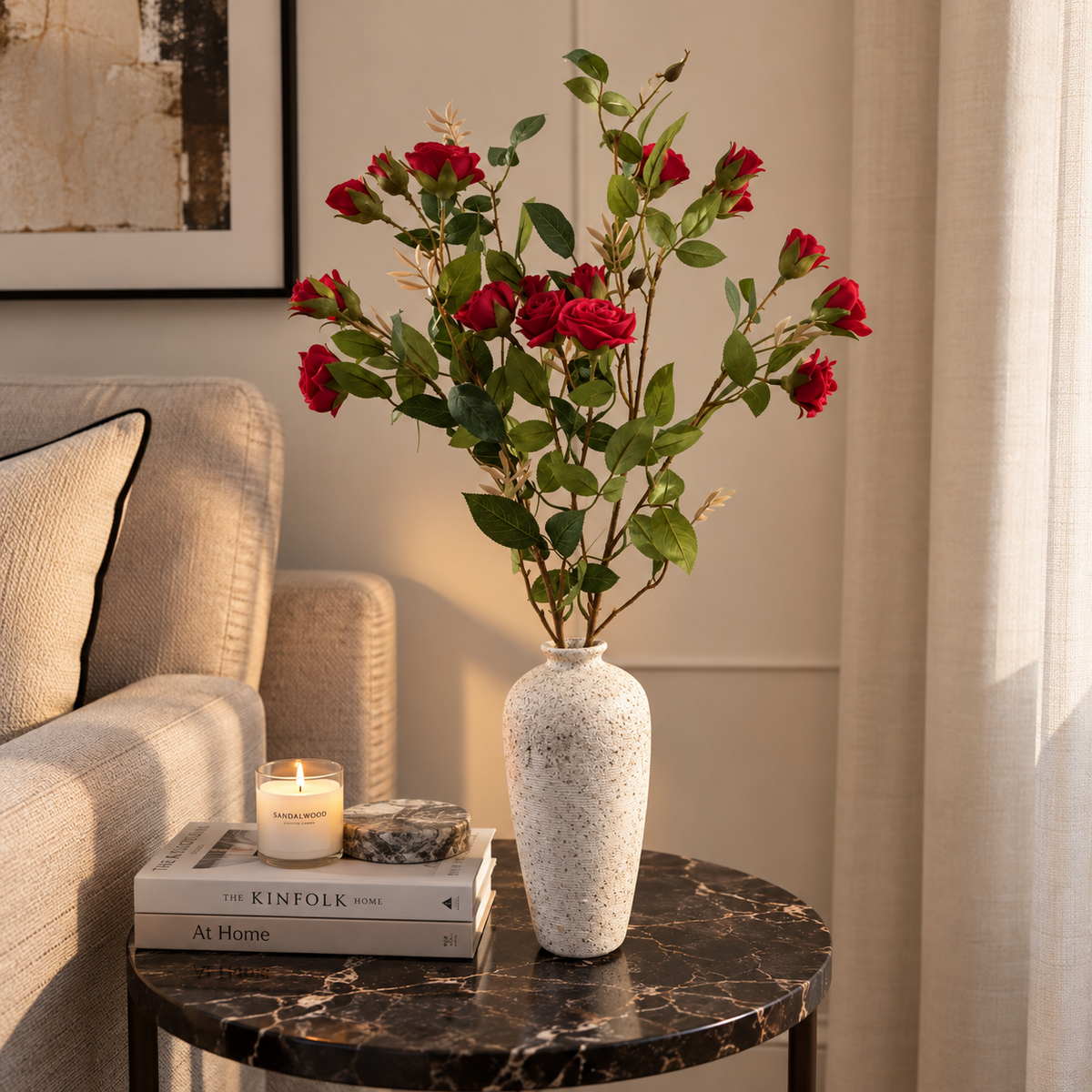 Long red rose stems in speckled white vase with green leaves