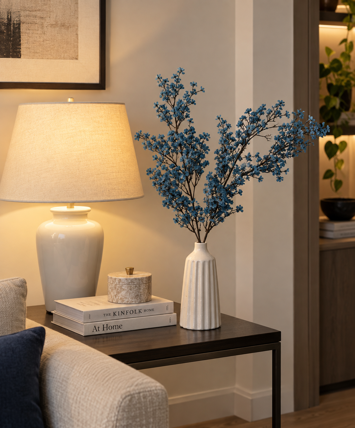 Blue blossom stems in white ceramic vase with long branched stems