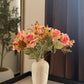 Peach and pink rose bunch with green leaves in speckled ceramic vase