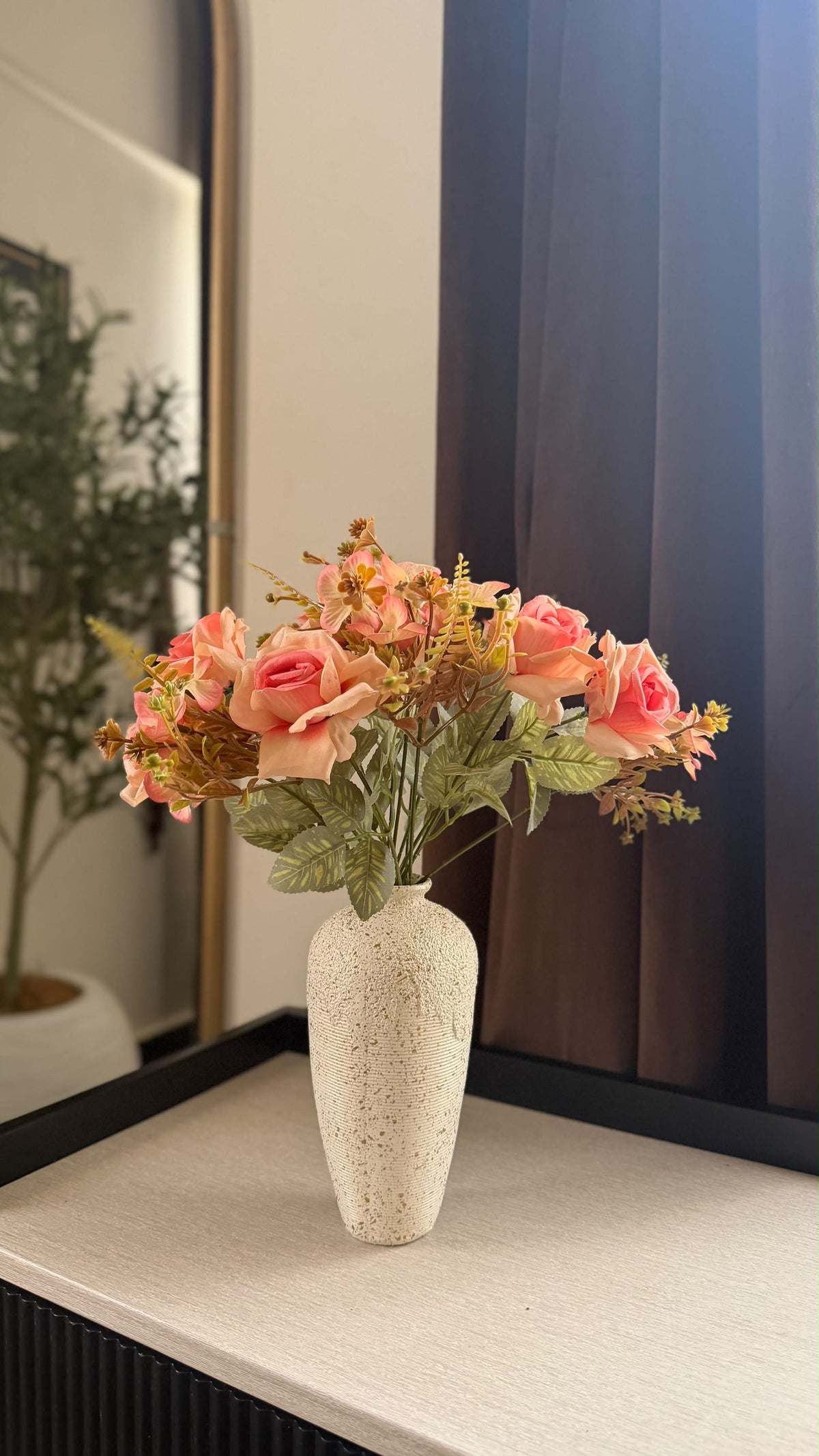 Peach and pink rose bunch with green leaves in speckled ceramic vase
