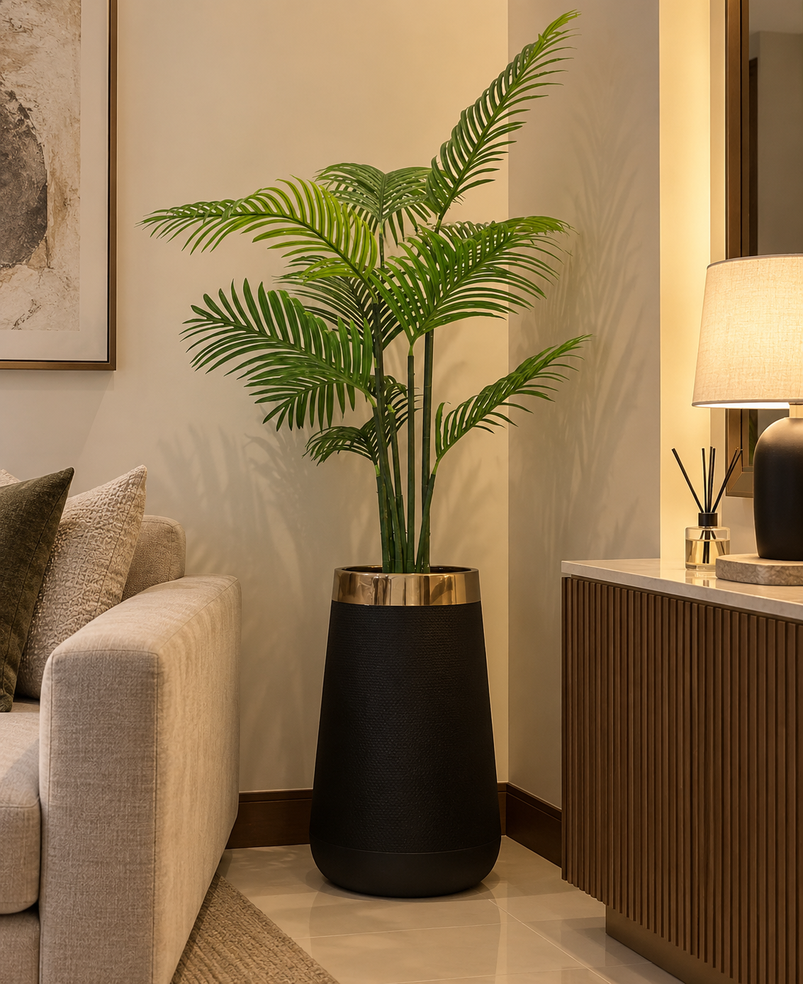Tall areca plant in a matte black pot, lush green fronds and slender trunk.