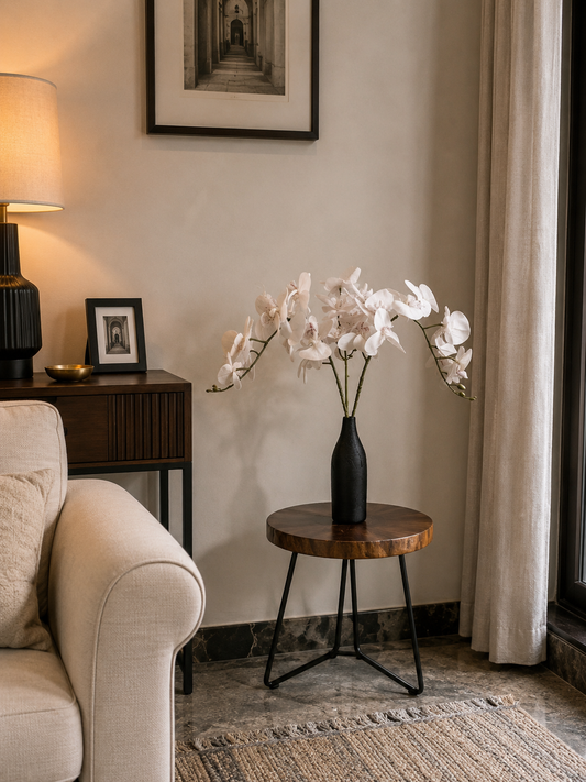 Long orchid stems with white blooms in a black round vase