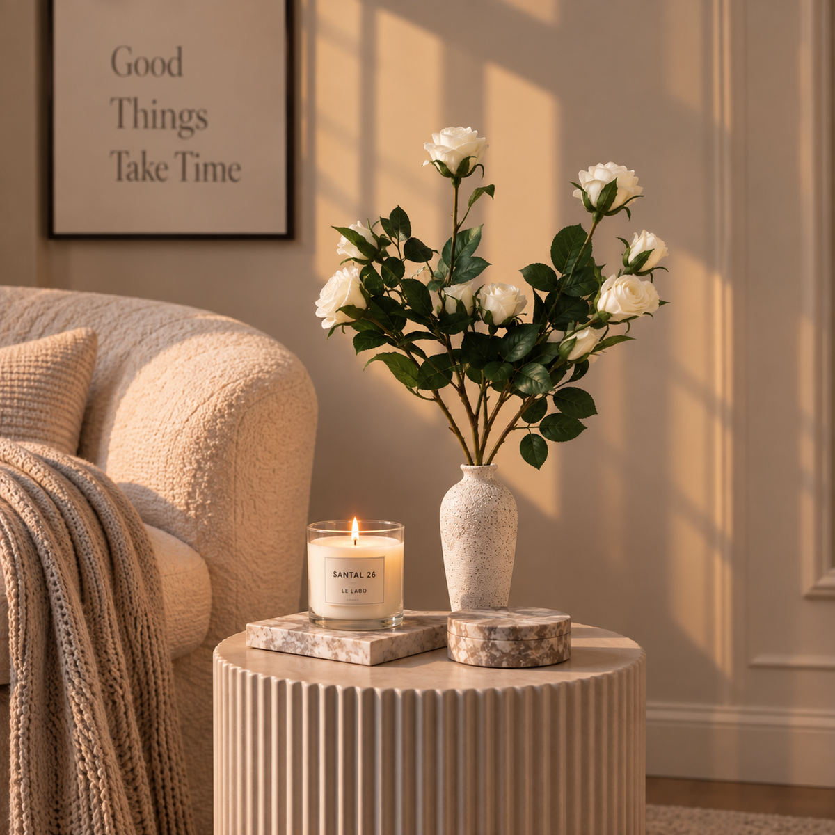 White rose stems with green leaves in speckled beige vase on round table