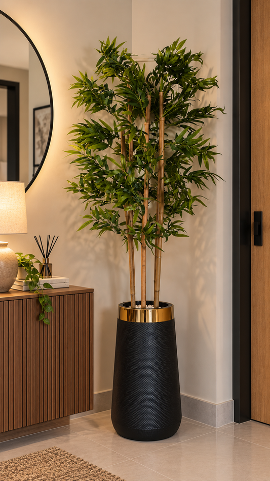 Tall bamboo plant with leafy green stems in a black planter pot