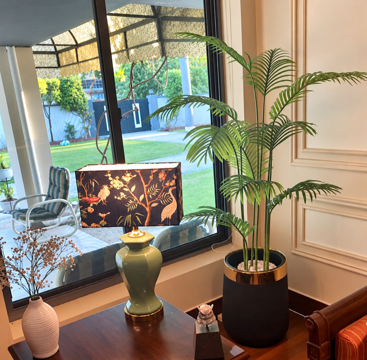 Tall areca palm plant with green fronds in a black pot