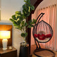 Tall guava plant with broad green leaves in black pot with gold rim